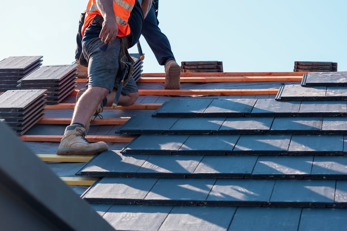 Professional roofing installation work on residential house